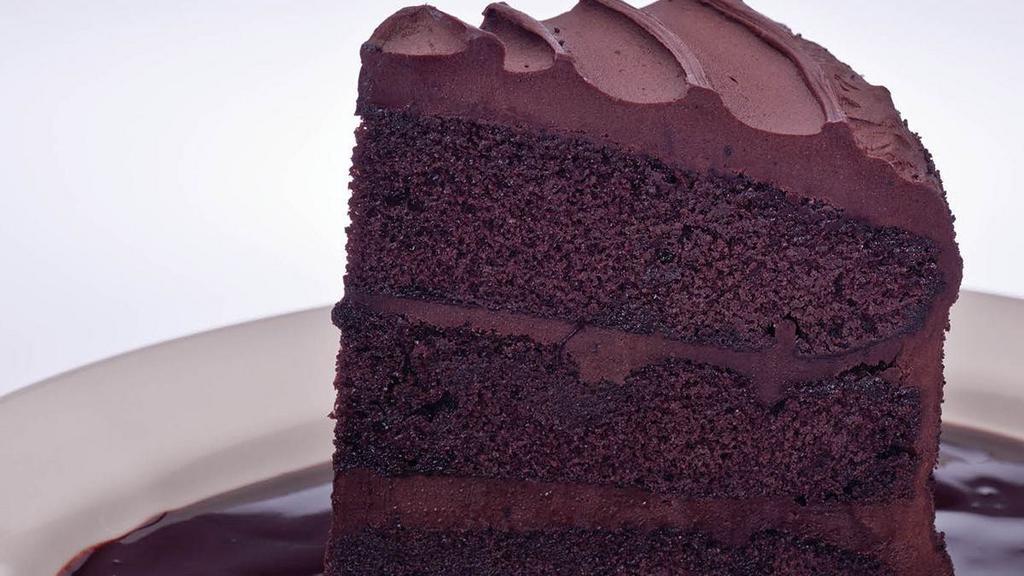 Double Dark Chocolate Cake · Moist dark chocolate cake with layers of rich chocolate frosting on top of our sinful chocolate sauce
