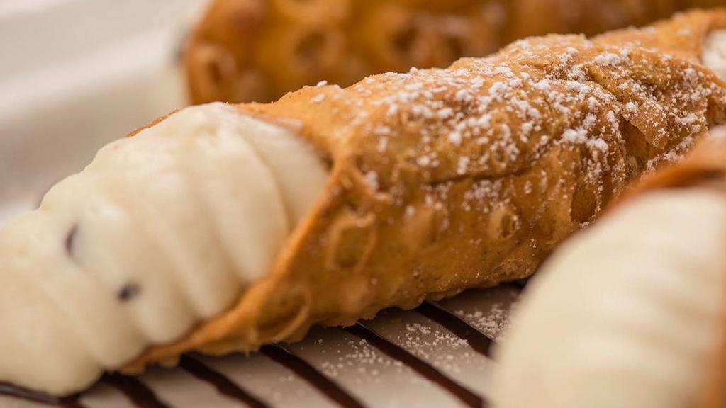 Chocolate Chip Cannoli · Crispy shells stuffed to order with a sweet, cannoli cream filling mixed with chocolate chips, served over a drizzle of our chocolate sauce