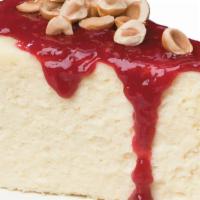 Homemade Cheesecake · Rich, creamy cheesecake topped with raspberry sauce and sprinkled with toasted hazelnuts