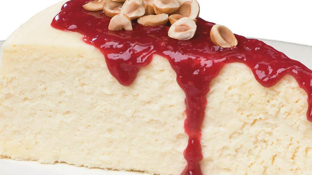 Homemade Cheesecake · Rich, creamy cheesecake topped with raspberry sauce and sprinkled with toasted hazelnuts