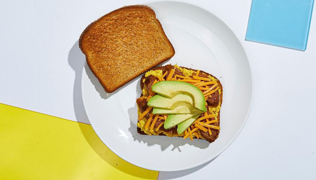 Vegan Breakfast Sandwich · Scrambled tofu with vegan sausage, sliced avocado, and vegan cheese between two slices of whole wheat toast.