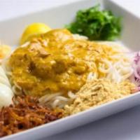 Nan Gyi Dok · Our traditional Burmese dish with rice noodles topped with coconut chicken sauce, yellow bea...