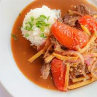 Lomo Saltado · Top sirloin strips stir fried with onions and tomatoes in a special Peruvian sauce - topped ...