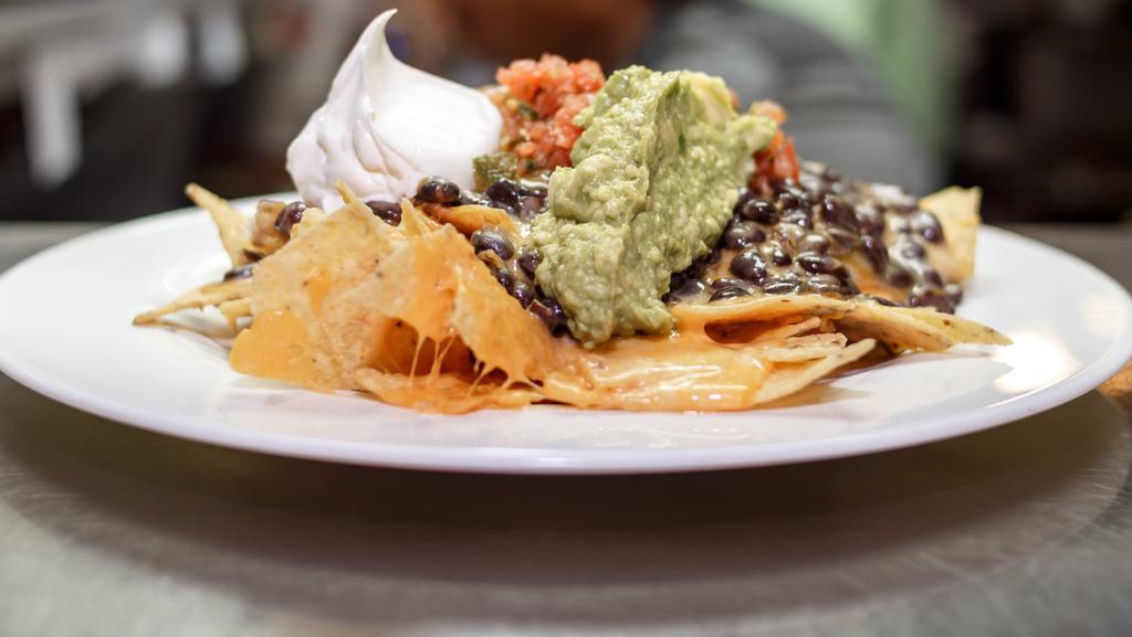 Nachos · Organic corn chips, sharp cheddar cheese, and black beans, topped with salsa, fresh guacamole, and sour cream.