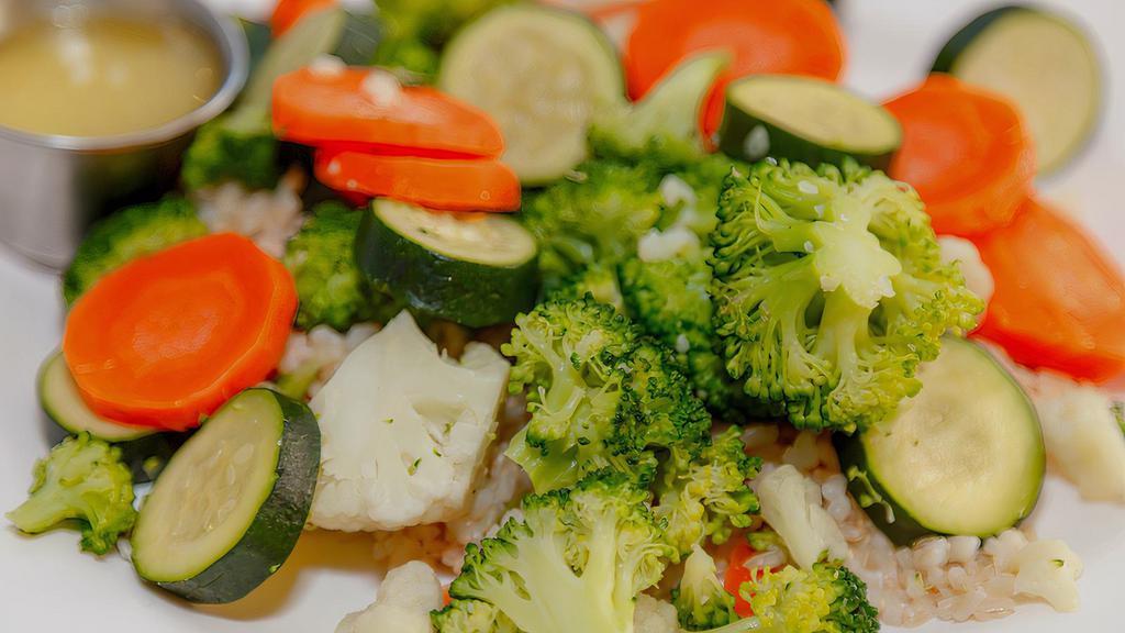 Steamed Vegetables · A medley of carrots, zucchini, cauliflower, and broccoli served over brown rice with lemon butter sauce.