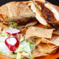 Torta · Choice of meat, refried beans, tomatoes, onions, lettuce, avocado, on a roll.