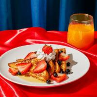 Berry French Toast · Four slices of thick, egg-washed cinnamon bread topped with fresh blueberries and strawberri...