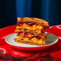 Bacon, Egg, and Cheese Stuffed French Toast · Two slices of thick, egg-washed cinnamon bread stuffed with crispy bacon, scrambled eggs, an...