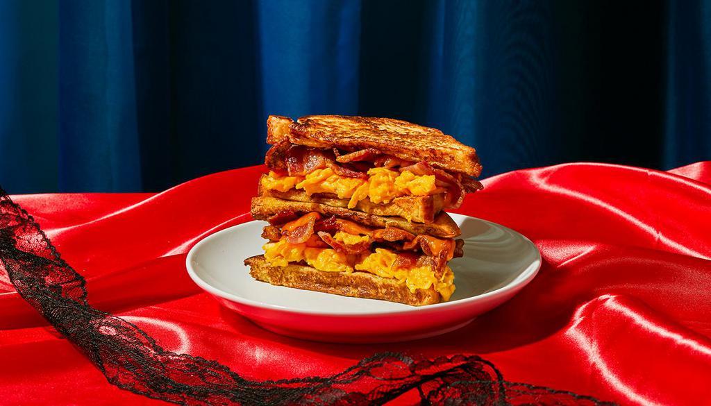 Bacon, Egg, And Cheese Stuffed French Toast · Four slices of thick, egg-washed cinnamon bread stuffed with crispy bacon, scrambled eggs, and melted cheddar.