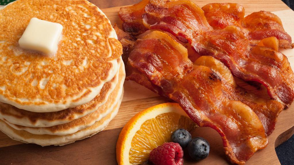 Pancake Breakfast Combo · The perfect Breakfast combo served with 2 Buttermilk pancakes, 2 slices of crispy Bacon, 2 pieces of Sausage, 3 cooked eggs, and a side of house potatoes.