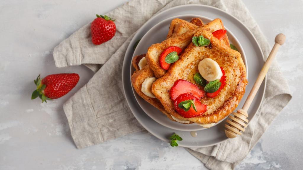Strawberry Banana French Toast · 2 slices of Classic French Toast freshly prepared and cooked to perfection. Topped with fresh strawberries and banana slices and served with syrup and hint of butter.