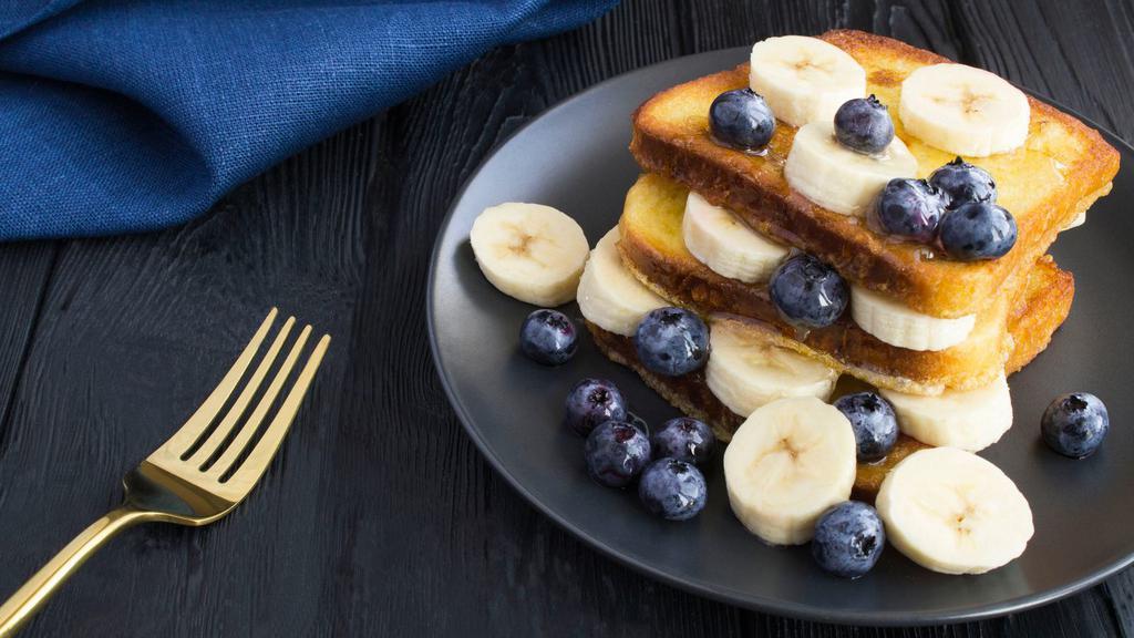 Blueberry Banana French Toast · 2 slices of Classic French Toast freshly prepared and cooked to perfection. Topped with fresh blueberries and banana slices and served with syrup and hint of butter.