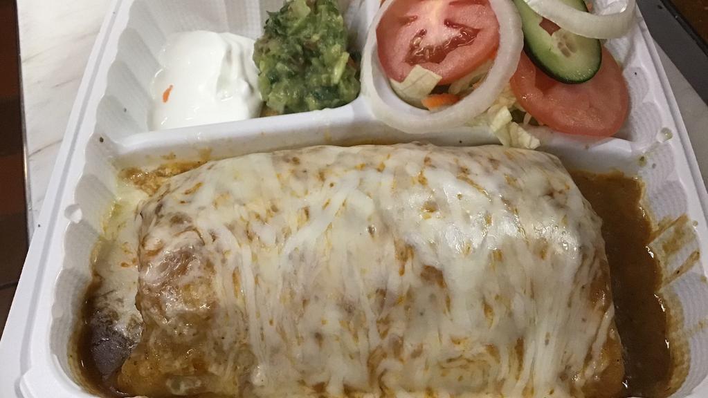 Burrito Mojado · A big burrito filled with onions, tomato, cilantro, guacamole, rice, beans, sour cream, grilled beef, chicken, carnitas, pork, wet in red or green sauce.