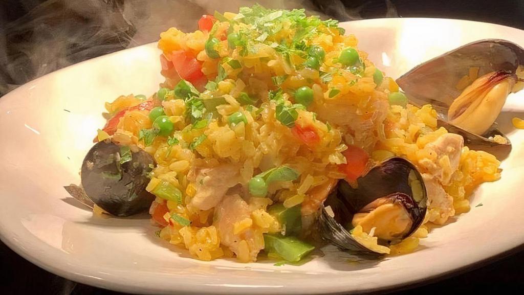 PAELLA · Mediterranean mussels, chicken, prawns, linguica sausage, bell pepper, green peas, tomato, bomba rice with saffron