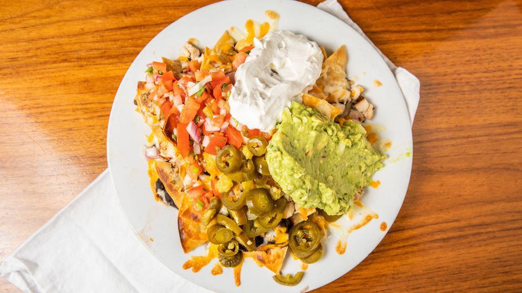 Novato Nachos · Homemade tortilla chips topped  with black beans, grilled chicken,  jack & cheddar cheese,  salsa fresca, guacamole, sour cream and jalapenos.