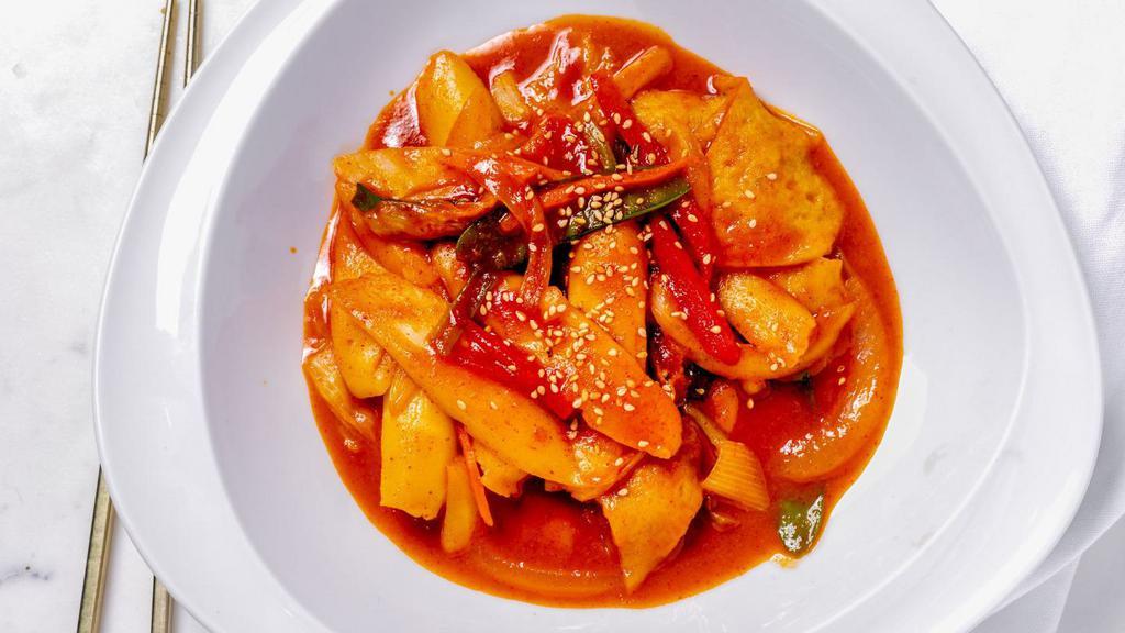 Spicy Rice Cake (Tteokbokki) · Chewy Korean rice cakes in a spicy sauce with fishcakes, onions, carrots, and scallions.