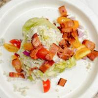 Wedge Salad · Freshly cut iceberg lettuce, red onions, cherry tomatoes, bacon, blue cheese crumble and our...