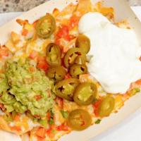 Super Nachos · Regular nachos with your choice of steak, chicken or carnitas, topped with guacamole and sou...