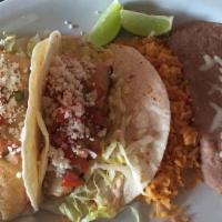 Fish Tacos · Two tacos on flour tortillas with chipotle taco sauce, let tuce, pico de gallo and Mexican c...