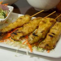 Sate · barbeque chicken skewers served with peanut sauce and cucumber salad on the side