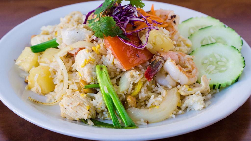 Pineapple Fried Rice · Fried rice with chicken, prawns, pineapple, egg, cashews, onions, tomatoes, and sliced of fresh cucumber.