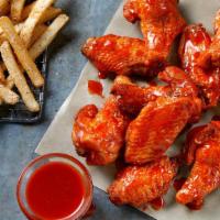 12 Bone-In Wings · 12 Bone-In Wings tossed in your choice of sauce,  served with seasoned fries and your choice...