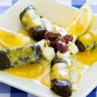 Dolmades Mezes · traditional grape leaves stuffed with seasoned ground sirloin and rice, served with lemon sa...