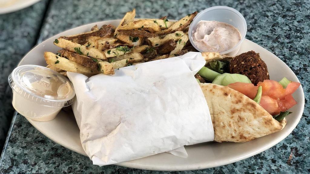 Falafel Pita Wrap(Vegetarian) · delicious falafel fried until crispy, wrapped in a warm pita with spring greens, cucumber, and tomato. served with tahini on the side