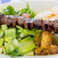 Lamb Souvlaki Plate · Tender pieces of marinated lamb loin grilled on a skewer, served with rice and vegetable med...