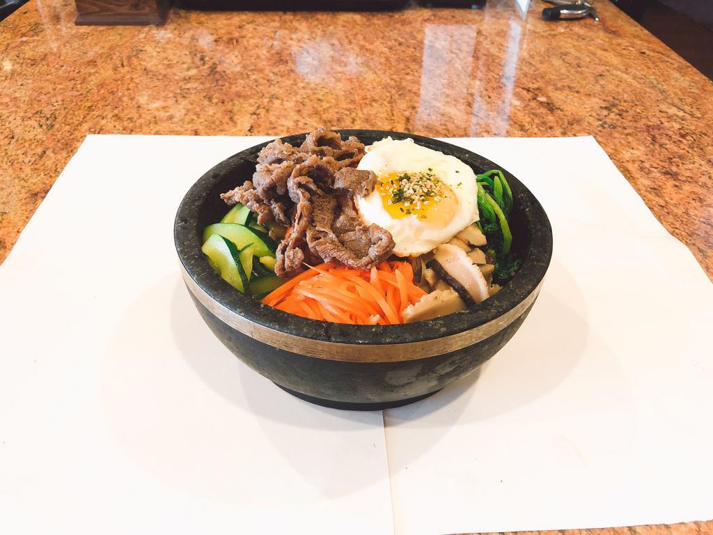 Hot Stone Bowl Bibimbop (돌솥비빔밥) · A bed of bean sprouts, spinach, mushroom, zucchini and julienned carrots served over rice and sesame oil. Topped with a fried egg and thinly sliced beef in a hot stone bowl.