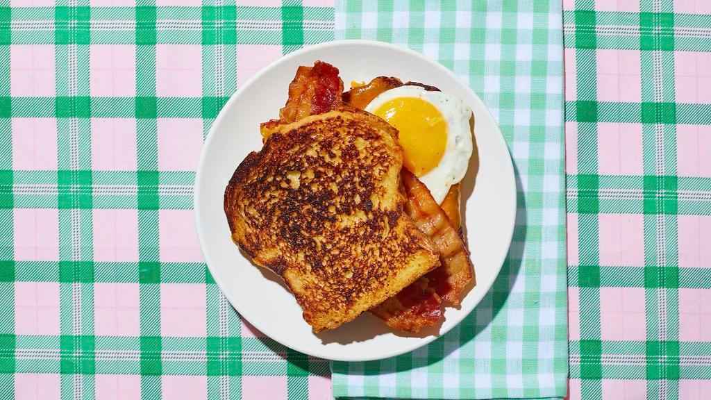 Le Bacon, Egg, and Cheese French Toast Sandwich · Get ready to be “le stuffed.” Bacon, fried egg, and cheddar cheese sandwiched between 2 slices of classic French toast.  Served with syrup on the side.