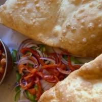 Chole Bhature (2 Pcs) · Puffed bread deep fried and served with garbanzo beans, raita, and homemade pickle.