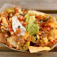 Vegan Sisig Nachos · Choice of protein with corn tortilla chips topped with nacho cheese, sour cream, guacamole, ...