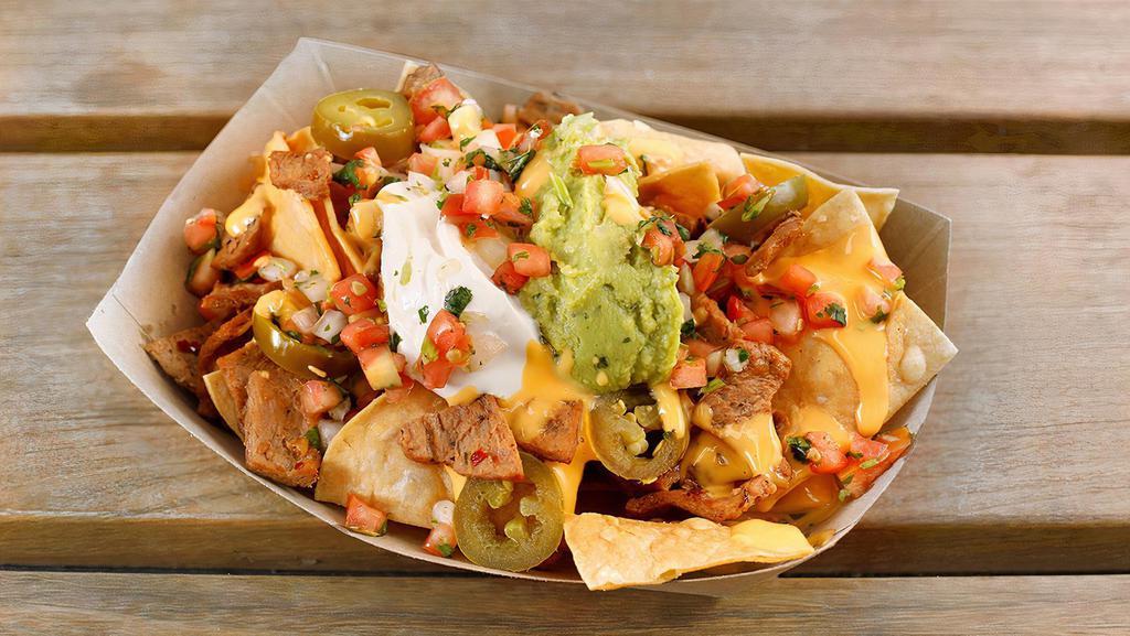 Vegan Sisig Nachos · Choice of protein with corn tortilla chips topped with nacho cheese, sour cream, guacamole, pico de gallo & pickled jalapeños