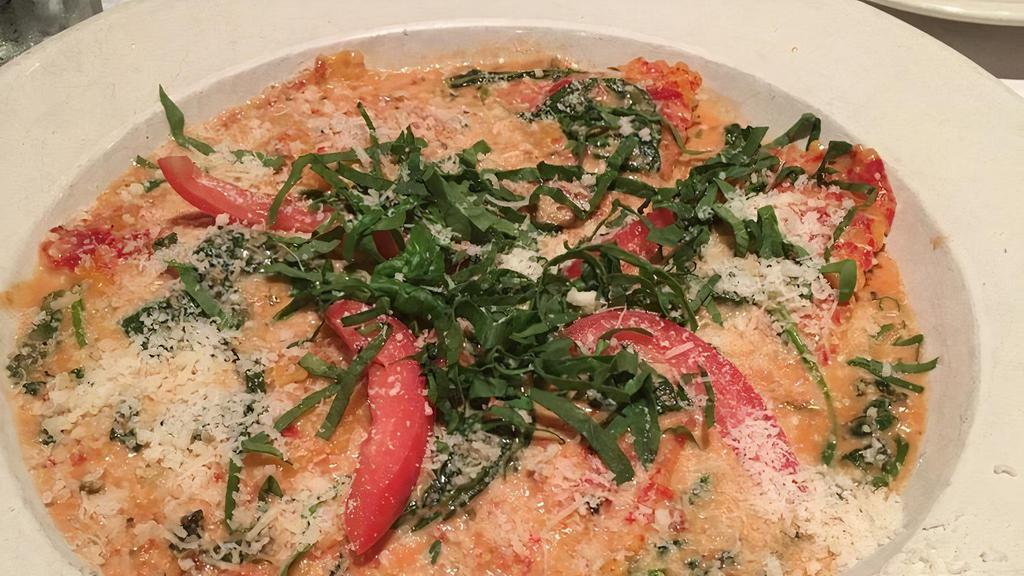 Crab Ravioli · Crab meat ravioli in a florentine sauce, topped with fresh spinach and tomatoes.
