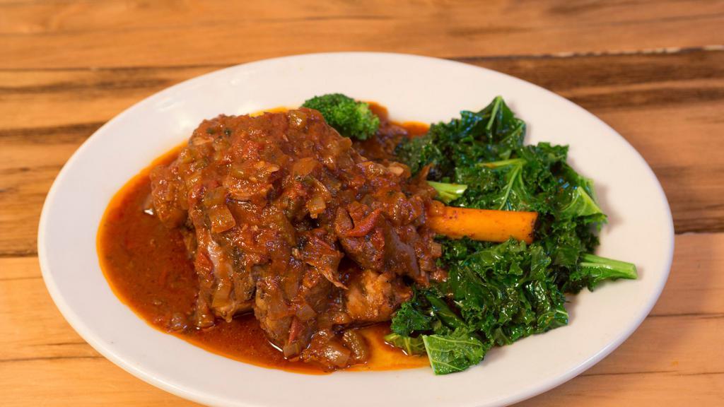 Lamb Shank · Braised in wine and vegetable sauce served over sautéed kale.