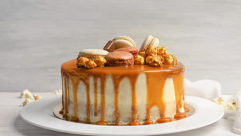 Caramel Mystique · A South American dessert with a tropical twist. A chocolate cake filled with dulce de leche mousse, a chocolate dipped sesame nougat brittle layer, banana mousse center, wrapped in a chocolate jaconde oval pattern, apricot glaze finish topped with a milk chocolate tuile garnish.