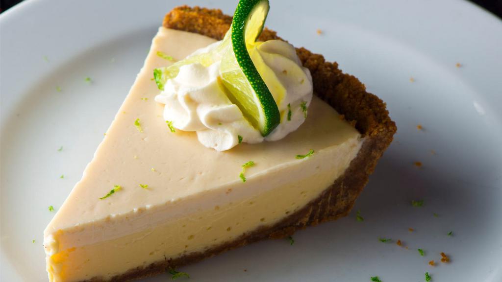 Key Lime with Meringue · A buttery short dough tart shell filled with key lime curd, sprinkled with granulated sugar topping, torched until caramelized, and finished with a light dusting of confectionery sugar.