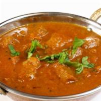 Chicken Karahi · Fresh boneless chicken sizzling in a bowl with house-made spices.
