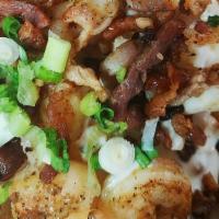Chowder Fries · House made New England Clam Chowder over garlic fries topped with bacon, parsley, green onio...