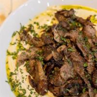 Hummus Lamb Shawarma · Hummus topped with Lamb cooked with spices. Hummus is served with 2 Pitas, Pickles, Tahini s...