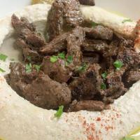 Hummus Beef Shawarma · Hummus topped with Beef cooked with spices. Hummus is served with 2 Pitas, Pickles, Tahini s...