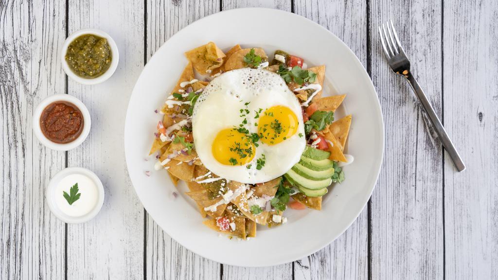 Chilaquiles · Vegetarian. Deep fried organic tortilla chips, tossed in fresh Chile Verde tomatillo sauce and served with two fried eggs, tomatoes, onions, Cotija cheese, cilantro, and avocado drizzled with a light crema.