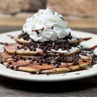 Chocolate Pancakes · Three chocolate pancakes, chocolate chips, powdered sugar, whipped cream.