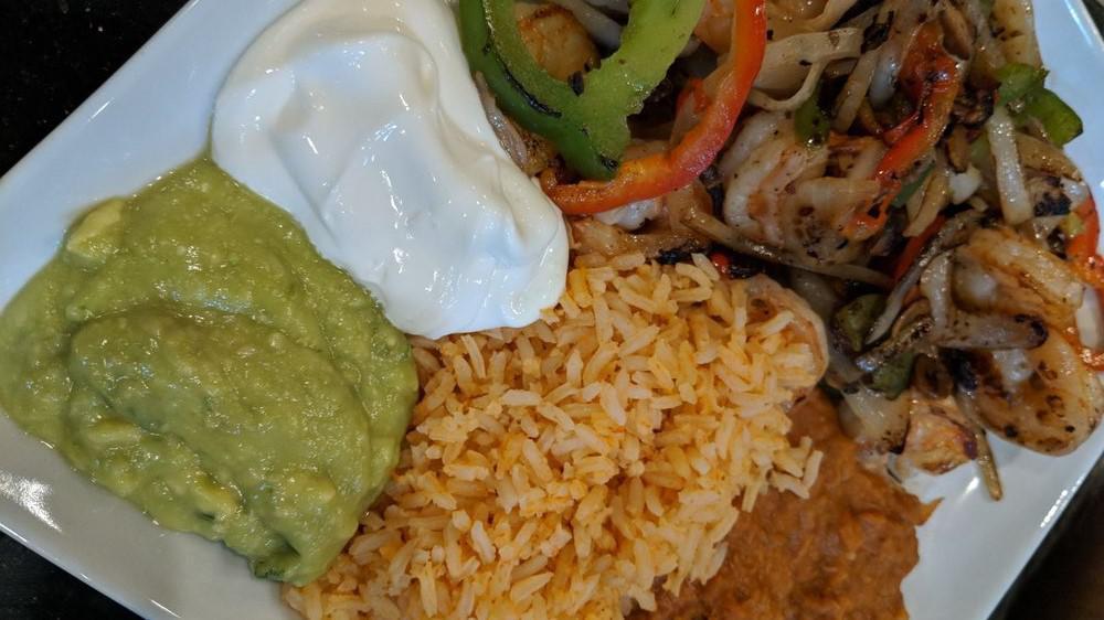 Fajitas · Choice of beef or shrimp, served with rice, refried beans, guacamole, sour cream and tortillas.