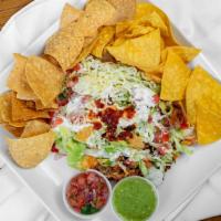 Tostada · One, served with choice of meat, refried beans, lettuce, tomatoes, cheese, sour cream, and g...