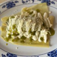 Uchepos (sweet corn tamale) · Sweet corn tamale topped with green sauce, sour cream, and Mexican cheese