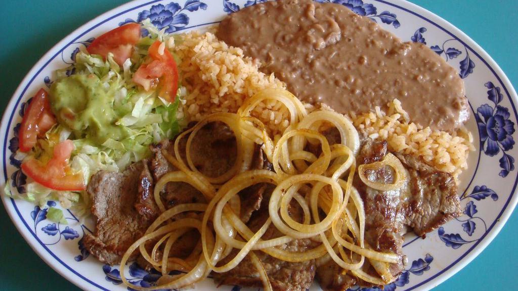 Carne Asada · Delicious, grilled steak with grilled onions on top. Served with rice, beans, salad and tortillas.