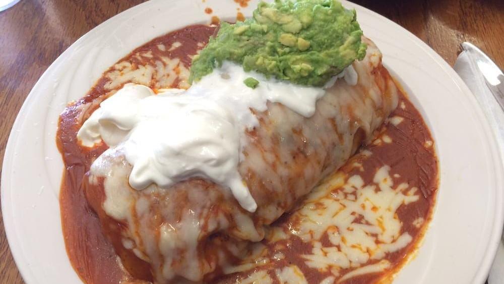 Burrito De Chile Relleno · Chile relleno, rice and beans stuffed in a flour tortilla and topped with cheese and tomato sauce.