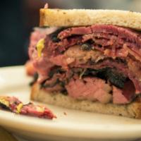 Pastrami and Ham Hot Sandwich · Thinly sliced pastrami and classic fresh ham, swiss cheese topped with poppy seeds, served w...